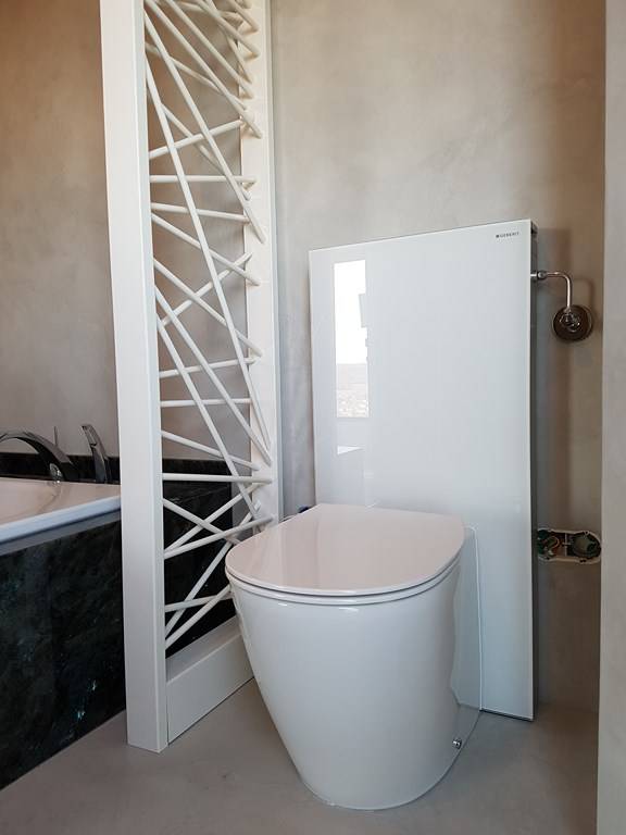 wc au sol avec réservoir dissimulé dans un habillage en verre Gébérit Monolith 